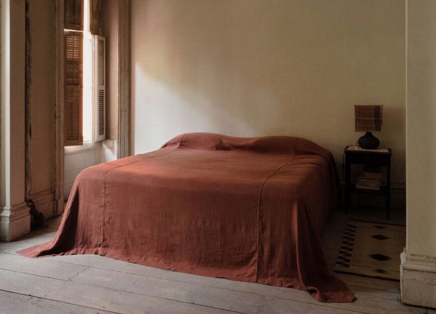 A bed with red linen sheets