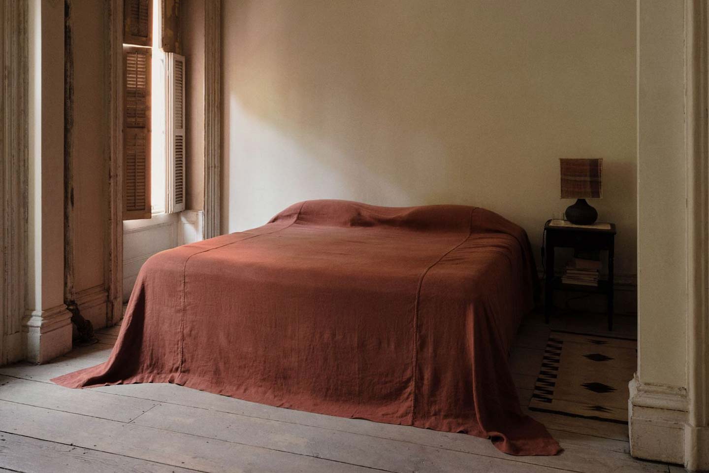 A bed with red linen sheets