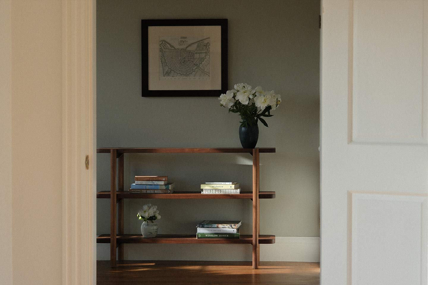 Wooden three tier shelf with flowers on it