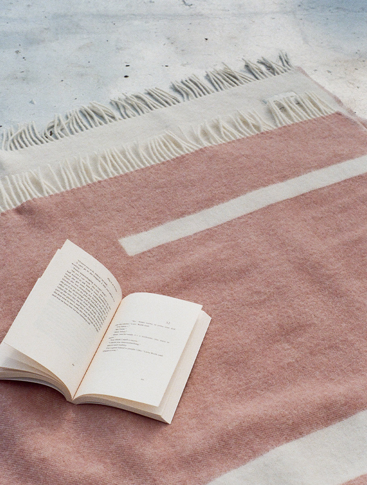 forestry-wool-river-wool-blanket-dusty-pink-product-image-blanket-laid-out-on-floor-with-open-book