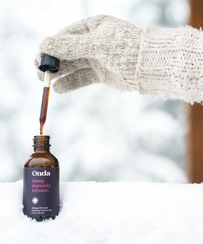 onda-wellness-innate-immunity-cbd-oil-product-lifestyle-image-bottle-outside-in-snow-glove-hand-holding-dropper