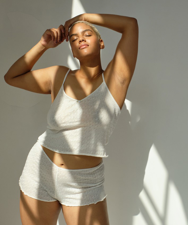 renue-the-label-organic-cotton-pointelle-cami-top-and-shorts-product-lifestyle-image-posing-model-woman-light-and-shadows