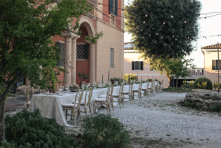 A large dinner table set outside Villa Lena in Italy