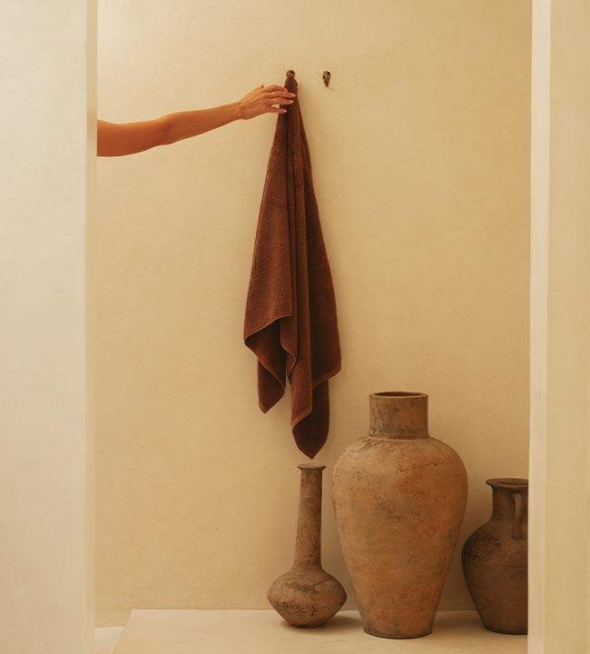 hand reaching for towel during a bathing ritual