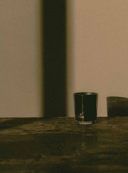 UMM Ayurvedic jasmine candle on a wooden shelf