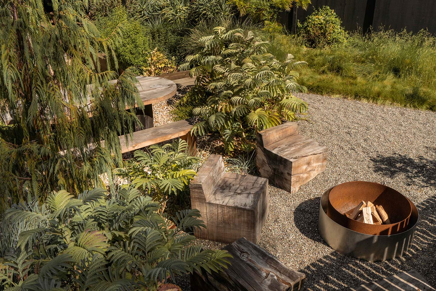 Outdoor sitting area with fire pit surrounded by native plants