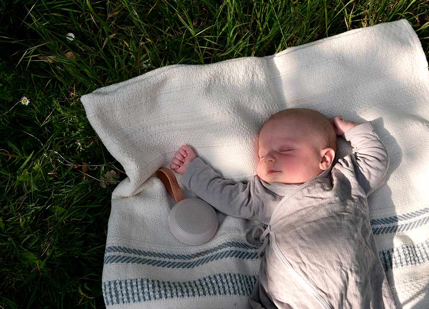 baby napping in a sleep sack outside in the fresh air