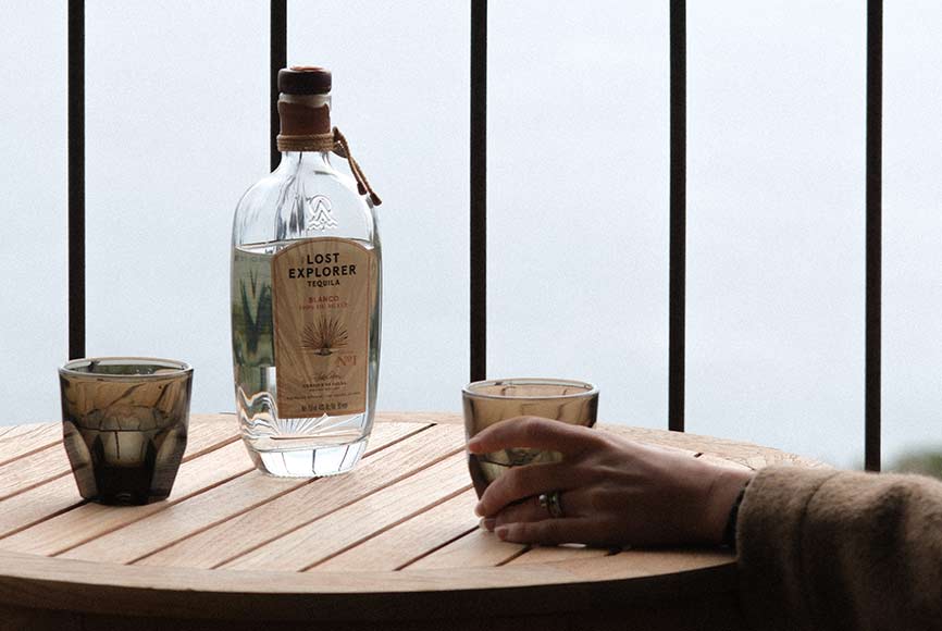 Organic tequila bottle by The Lost Explorer on a wooden table