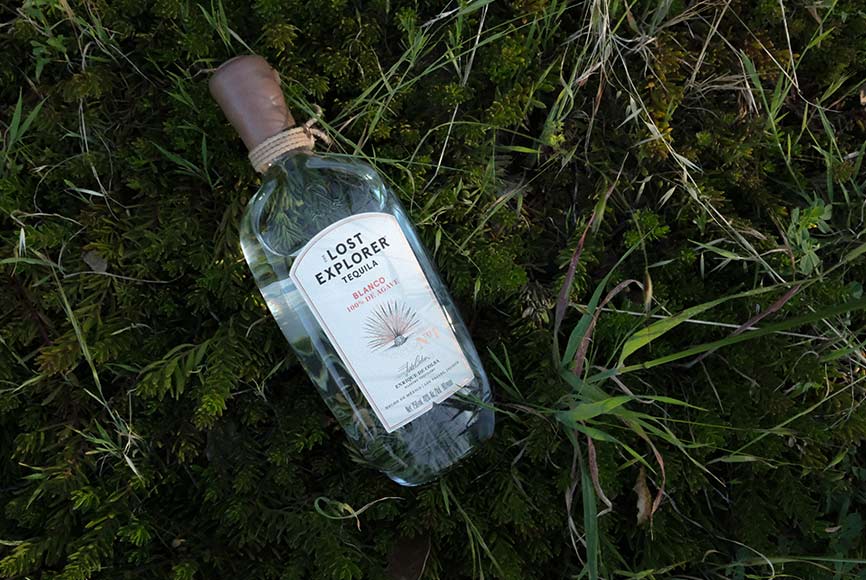 A Lost Explorer bottle in the tall grass