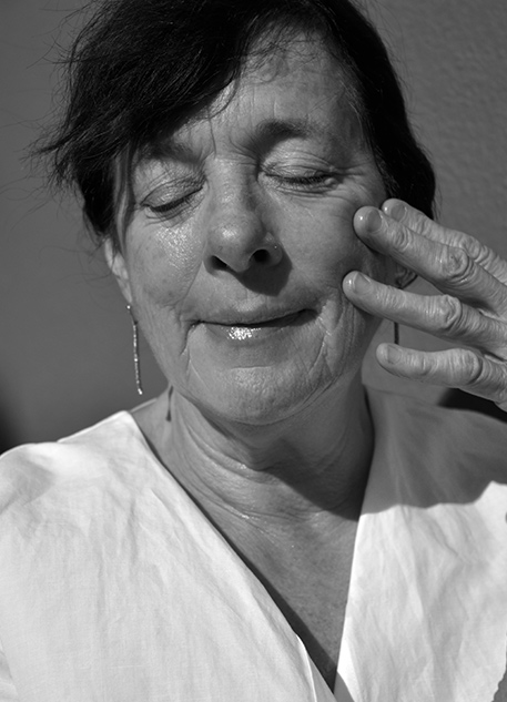 An older woman applying natural face oil