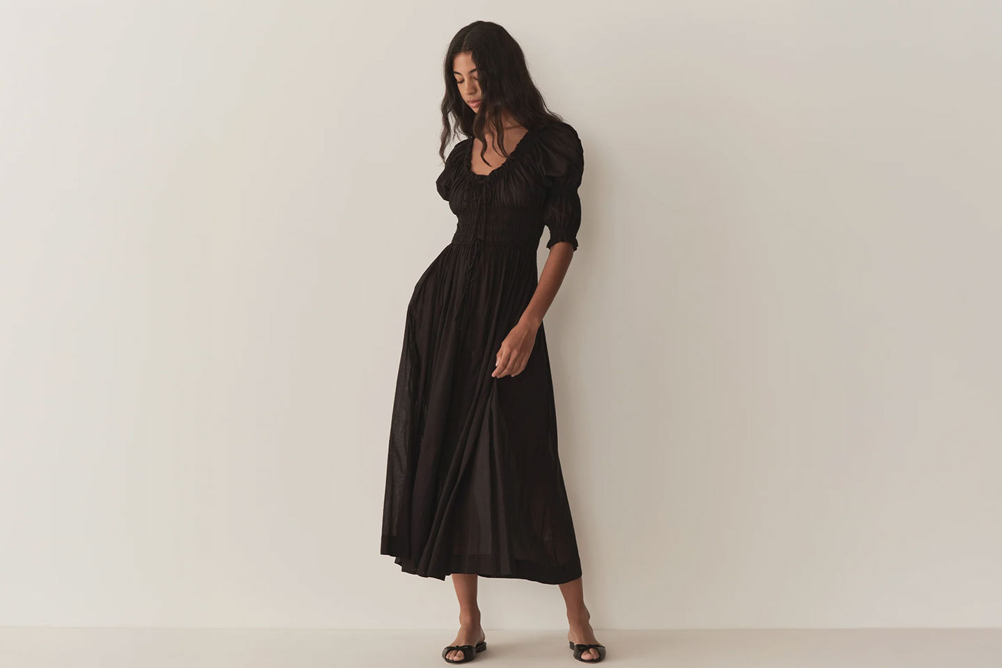 A simple black cotton dress on a model