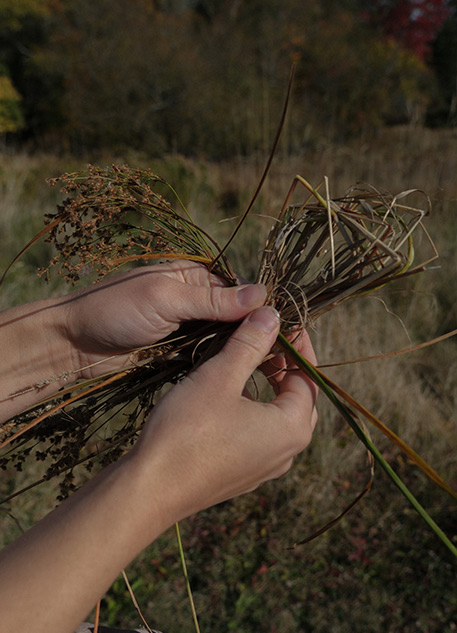 Woman making a heart out of dried grasses