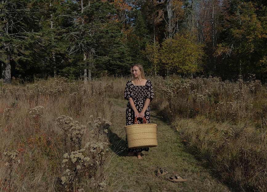Woman in a field holding a basket