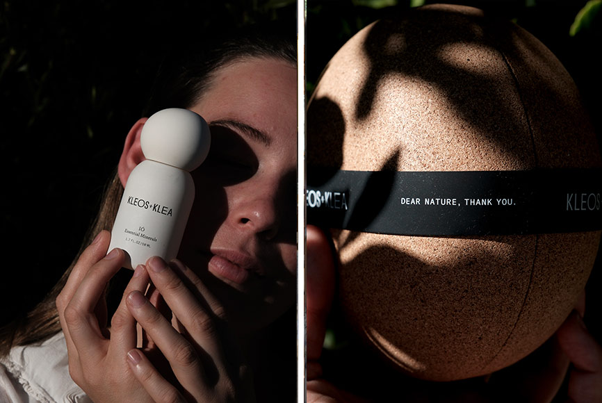 A woman holding a white bottle of skincare next to her face