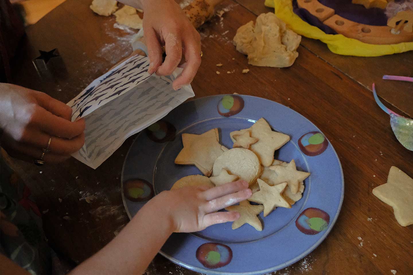 A child putting sugar cookies into a paper bag