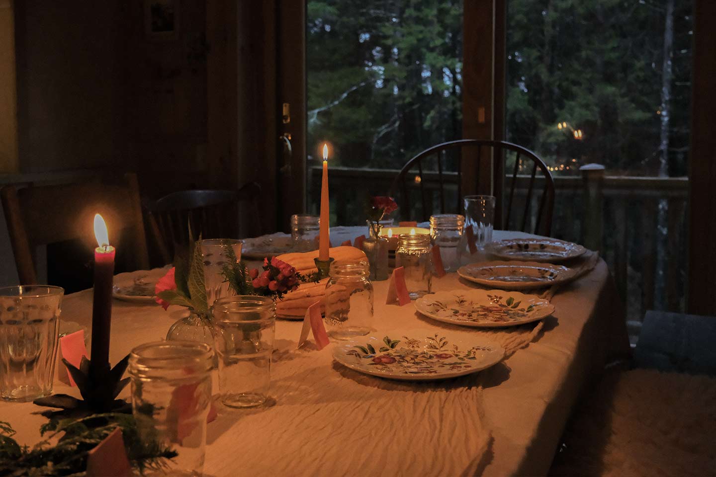 Dinner table set with dishes and candlelight