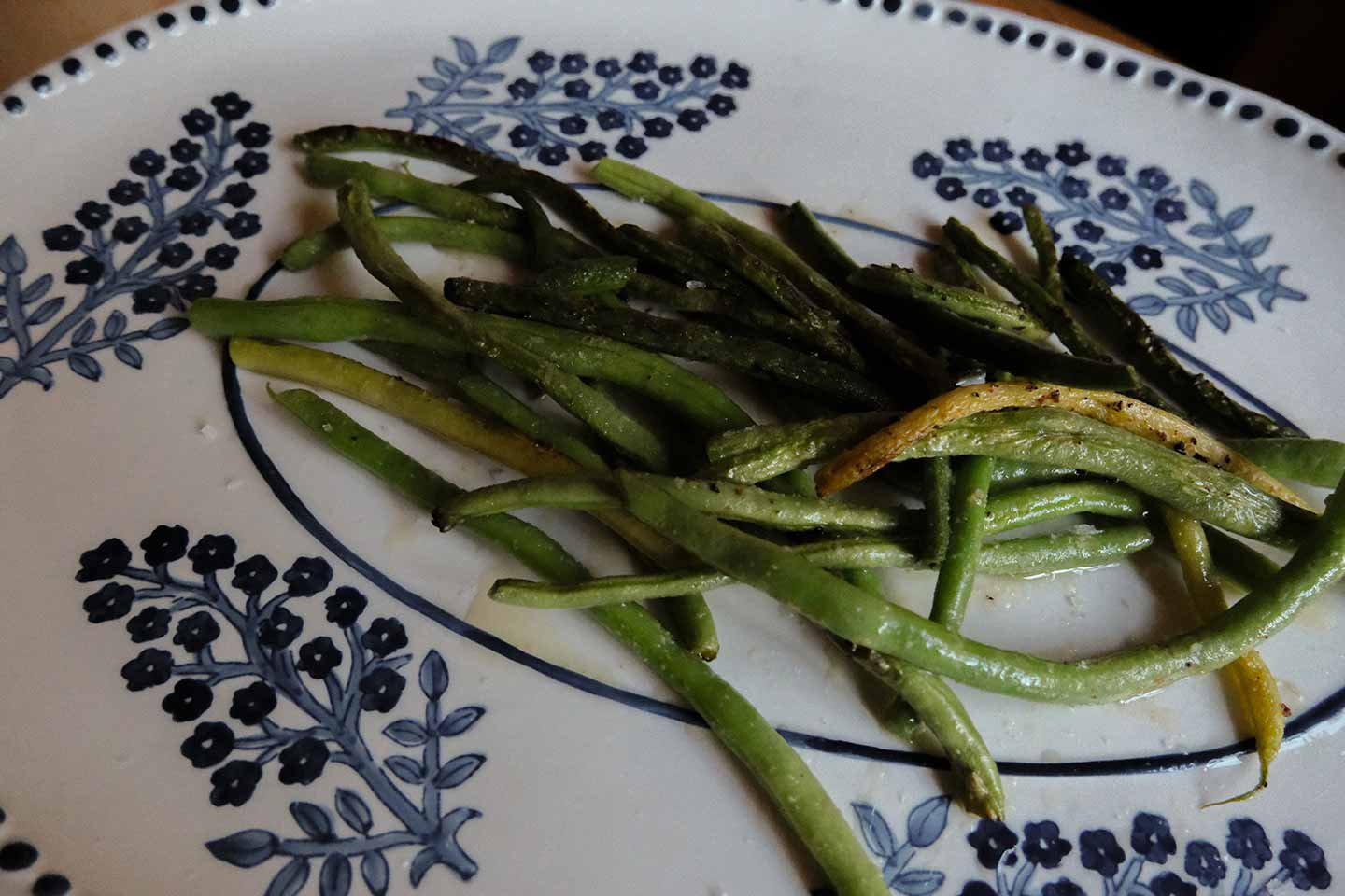 Cooked green beans on a flowered platter