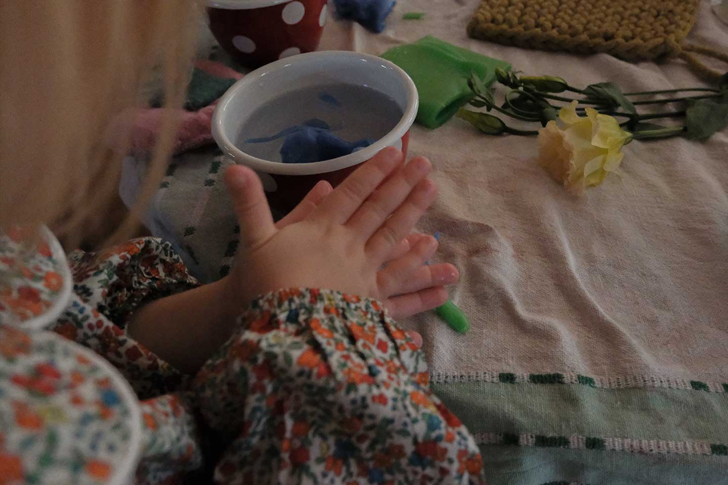A child playing with a ball of clay at a table