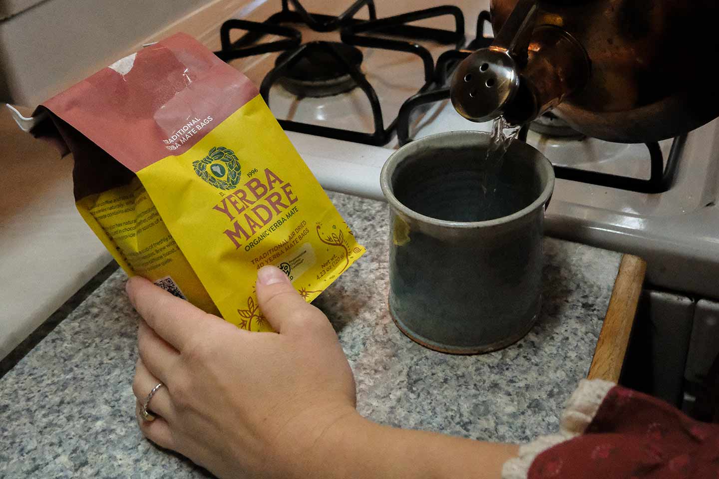 A close up of a woman brewing Yerba Madre tea