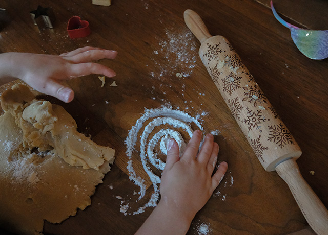 A child drawing a circle with flour while baking