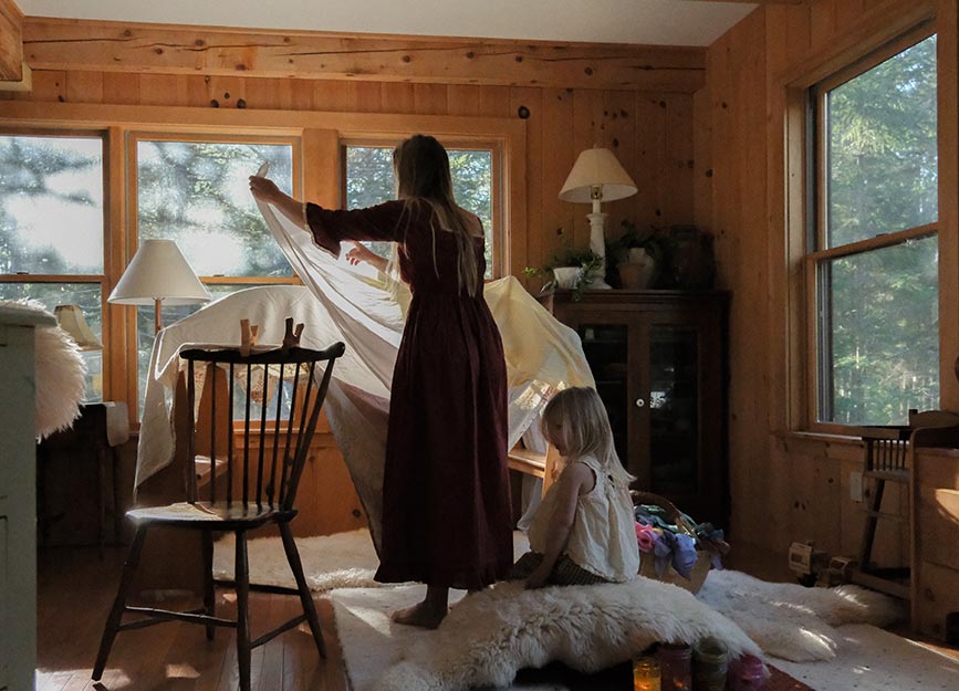 A woman building a fort with her two young daughters