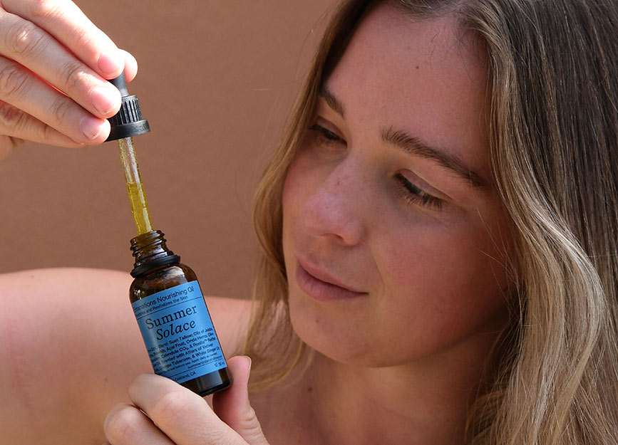 A woman holding a bottle of tallow face oil