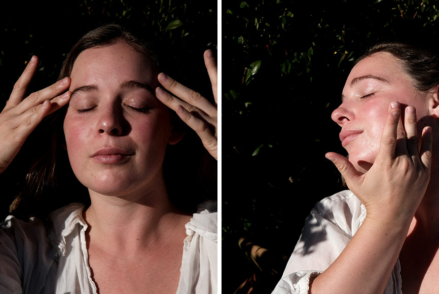 A young woman giving herself a facial massage