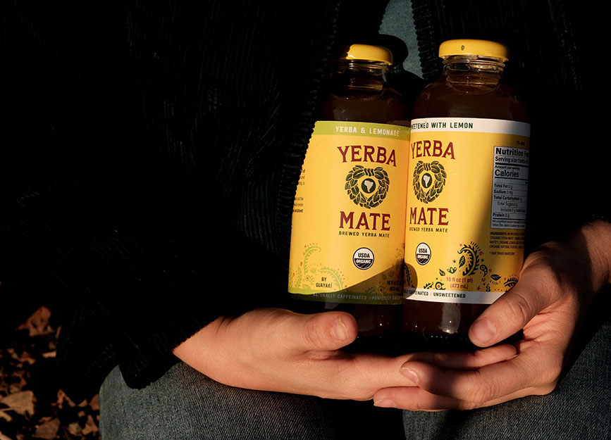 A woman holding bottles of Yerba Mate tea