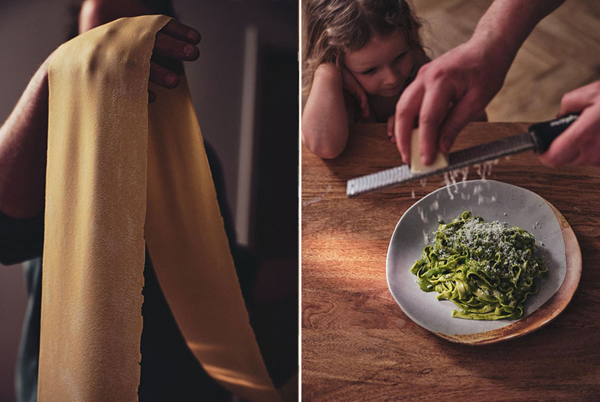 A man rolling out fresh pasta and serving it to his daughter with pesto
