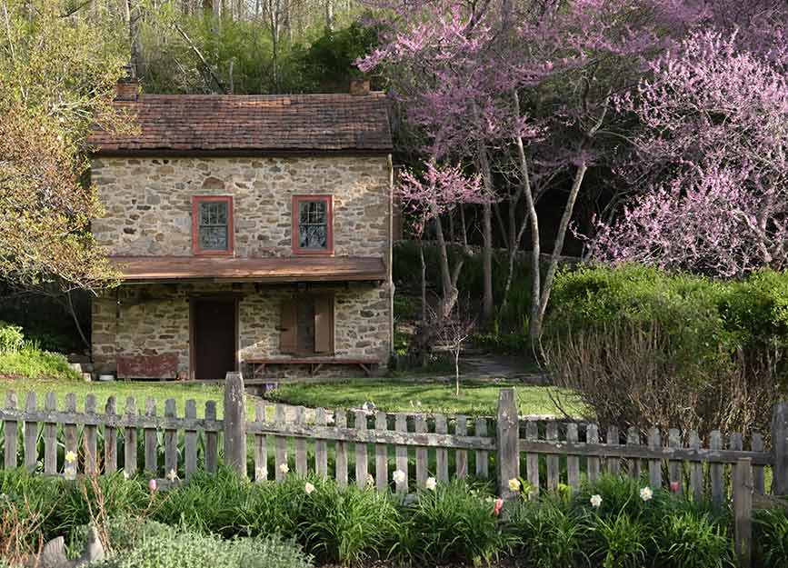 A stone barn next to cherry trees
