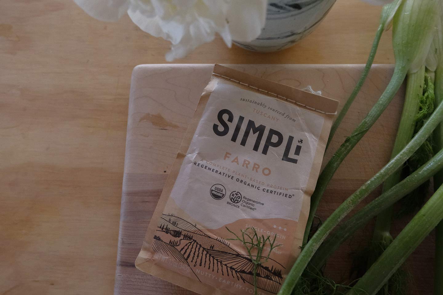 A bag of Simpli farro on a wooden cutting board