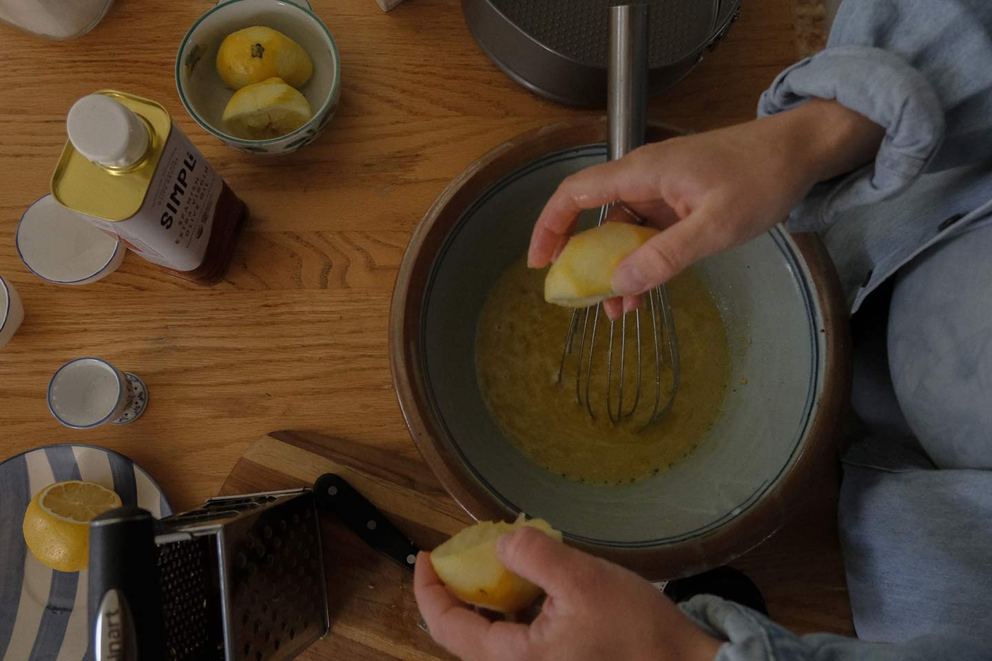 A woman squeezing lemons into cake batter