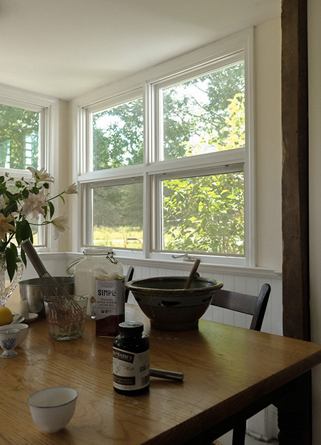 A kitchen table with ingredients for olive oil cake set out upon it
