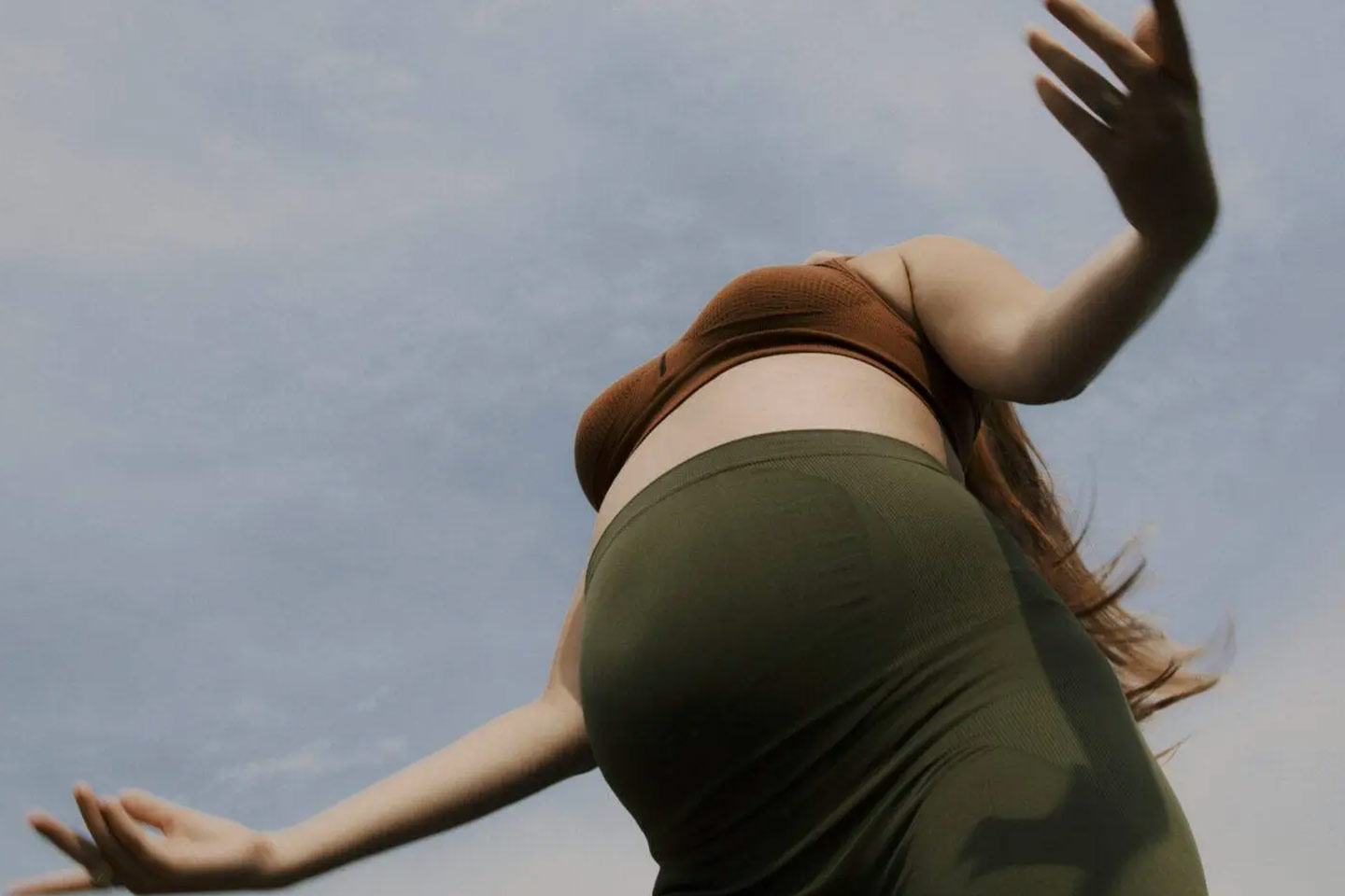 A pregnant woman in green maternity leggings