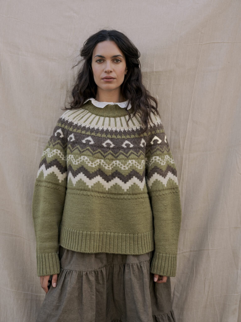 A woman wearing a green statement sweater
